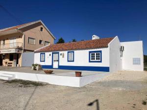 a small white and blue house in front of a building at Casa Isqueiro in Cela