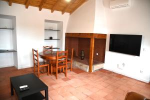a living room with a table and a fireplace at Casa Isqueiro in Cela