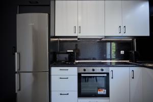 a kitchen with white cabinets and a stove and refrigerator at ChioSmart Town Apartments in Chios