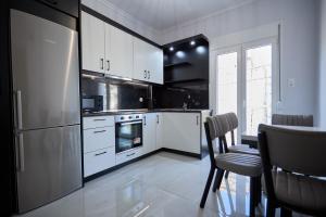 a kitchen with white cabinets and black appliances at ChioSmart Town Apartments in Chios