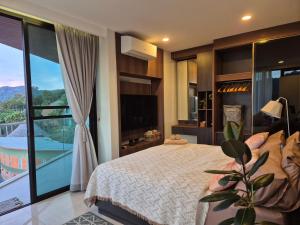 Un dormitorio con una cama grande y una ventana grande. en The viva patong condo C602, en Patong Beach 53 fotos más