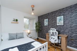 a bedroom with a bed and a desk at Open Mind Property - 3 Bed Home with Free Parking in Portsmouth