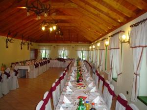 um grande salão de banquetes com mesas e cadeiras com em Guest accomodation Lovacka kuca em Grdak