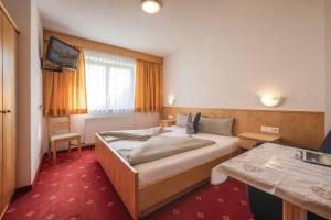 una habitación de hotel con una cama y un televisor en Haus Ferienglück, en Neustift im Stubaital
