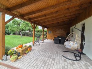 a patio with a chair under a wooden pergola at Villa V53 Siófok in Siófok