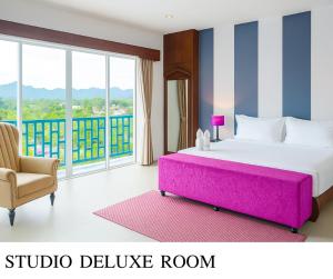 a bedroom with a large bed and a chair at The Bridge Residence Hotel in Kanchanaburi +70 photos