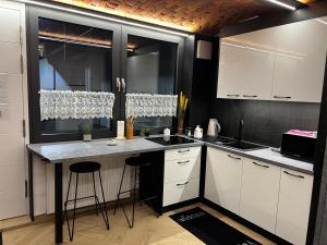 a kitchen with white cabinets and a counter top at Limba Home in Nysa