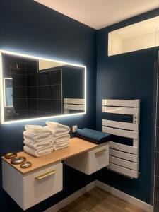 a bathroom with a vanity with a mirror and towels at Le Chai des Poilanes in Liré