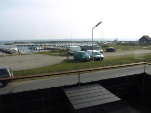a parking lot with cars parked next to a harbor at Super Apartment In The First Row With A 180-Degree Sea View in Spodsbjerg
