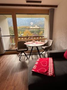 a living room with a table and chairs and a large window at Apartment Elisabeth in Obertraun +21 photos