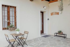 a table and chairs in a white room with windows at La Cocca Home in Bellinzago Novarese
