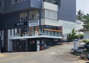 a large white building with a sign that reads mercy coffee at The Beach Nook - Umdloti Holiday Resort in Umdloti