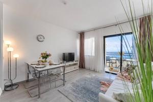 アデへにあるLuxurious and spacious apartmentのテーブルがあり海が見えるリビングルーム