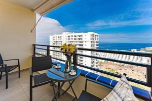 アデへにあるLuxurious and spacious apartmentのテーブルと椅子と海のあるバルコニー