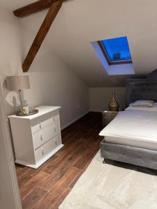 a bedroom with a bed and a dresser and a window at ROYAL Apartment in Kadaň