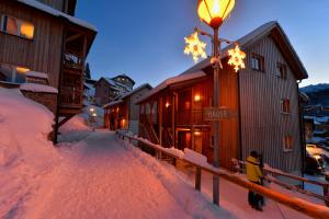a person standing next to a street light in the snow at Almresort Gartnerkofel Nassfeld in Sonnenalpe Nassfeld