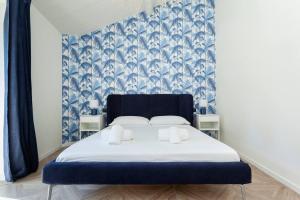 レンノにある"The Balbianello Lake House Blue"の青と白の壁紙を用いたドミトリールームのベッド1台分です。