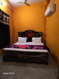 a bedroom with a large bed with flowers on it at Hotel diomand in Hardoī +3 photos