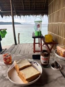 a table with a plate of peanut butter and toast at Mentari homestay in Besir