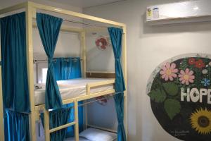 a bunk bed with blue drapes in a room at Kashi Vibes Hostel in Varanasi