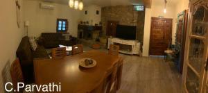 a living room with a table and a couch and a tv at CASA PARVATHI CANDELEDA in Candeleda