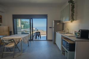 une cuisine avec une table et une vue sur l'océan dans l'établissement Azur Escale - Détente entre Mer et Montagne, à Maison Henou