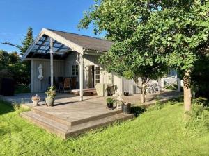 a house with a wooden deck in the yard at Stunning Home In Nykøbing Sjælland W in Nykøbing Sjælland
