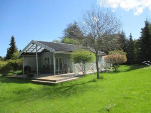 a small white house with a porch and a yard at Stunning Home In Nykøbing Sjælland W in Nykøbing Sjælland +11 photos