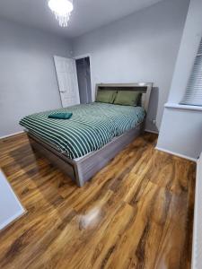 a bedroom with a bed and a wooden floor at The Walnut in Aveley