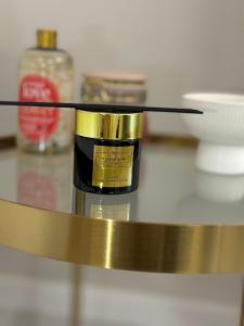 eine gold-schwarze Flasche auf einer Theke mit anderen Gegenständen in der Unterkunft Golden Eden Wieniawska - Rezydencja Ogród Saski in Lublin