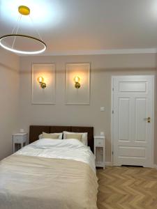 ein Schlafzimmer mit einem großen Bett mit zwei Nachttischen in der Unterkunft Golden Eden Wieniawska - Rezydencja Ogród Saski in Lublin