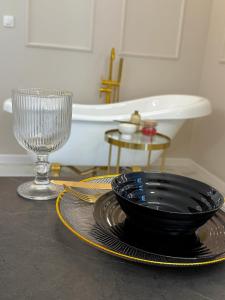 ein Tisch mit einem Teller, einer Schüssel und einem Glas in der Unterkunft Golden Eden Wieniawska - Rezydencja Ogród Saski in Lublin