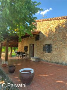 a stone house with a courtyard with a patio at CASA PARVATHI CANDELEDA in Candeleda