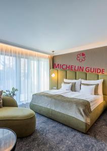 a hotel room with a large bed and a couch at Riva Prestige Hotel in Szeged