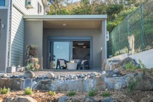 une maison avec une passerelle en pierre menant à la porte d'entrée dans l'établissement Azur Escale - Détente entre Mer et Montagne, à Maison Henou 5 autres photos