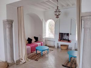 sala de estar con sofá y 2 sillas azules en Dar El kharrouba, en Hammamet Nord