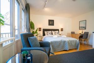 a bedroom with a bed and a chair and a table at Prime City Location, Spacious Studio Apartment in Gothenburg