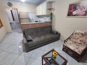 a living room with a couch and a chair at Casa com Piscina no Centro de Unamar em Cabo Frio in Cabo Frio