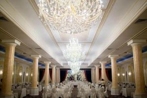 a large banquet hall with white tables and a chandelier at Hotel Ten Constanta in Constanţa