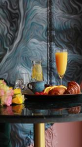 a tray with a glass of orange juice and croissants at VISIONAPARTMENTS Bucharest - contactless check-in in Bucharest +52 photos