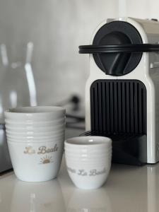 Tres tazas sobre un mostrador junto a una tostadora. en Studio Face Mer Santa Clara, en La Baule