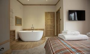 a bathroom with a tub and a bed with towels at Appletree Holiday Park in Boston