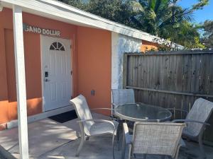 ボニータ・スプリングスにあるSand Dollar Updated Kitchen Washer Dryer On River 1 Mile to Beach Sleeps 4の家の前のパティオ(椅子、テーブル付)