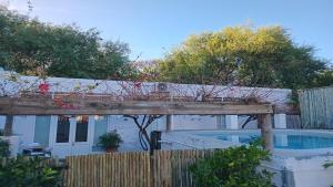 a wooden bridge over a fence with a swimming pool at The Barn On 62 - Cottages in Montagu