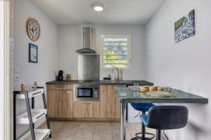 a kitchen with a counter and a table with chairs at Lacaze Salazie in Hell-Bourg