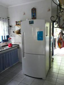 a white refrigerator in a kitchen with a sink at Casa Vilarejo, cond fech, ar cond, churrasq, piscina in São Sebastião