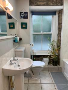 a bathroom with a sink and a toilet and a window at 2 bed apartment & parking, Carlops,10 mins drive Edinburgh bypass in Carlops