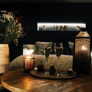 - une table avec deux verres à vin en haut dans l'établissement Appartement avec spa privatif, à Douai