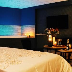 - une chambre avec un lit et 2 tables avec des bougies dans l'établissement Appartement avec spa privatif, à Douai 1 autre photo