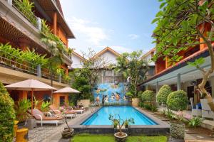 a swimming pool in the courtyard of a building at Lumbung Sari Hotel Legian in Legian